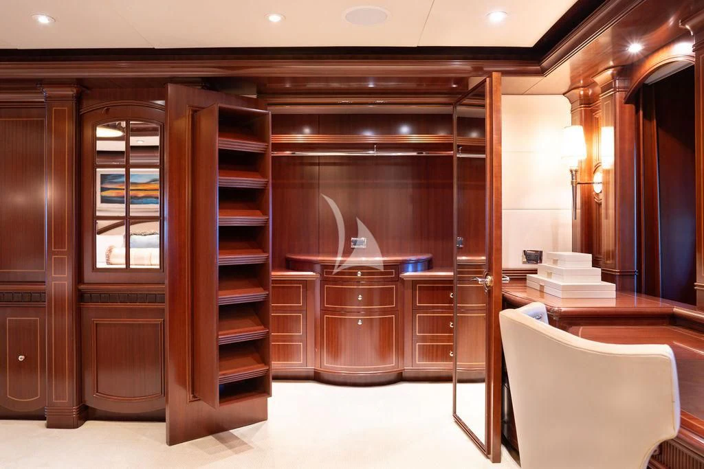 a room with a chair and a shelf with books on it aboard LADY BETH Yacht for Sale