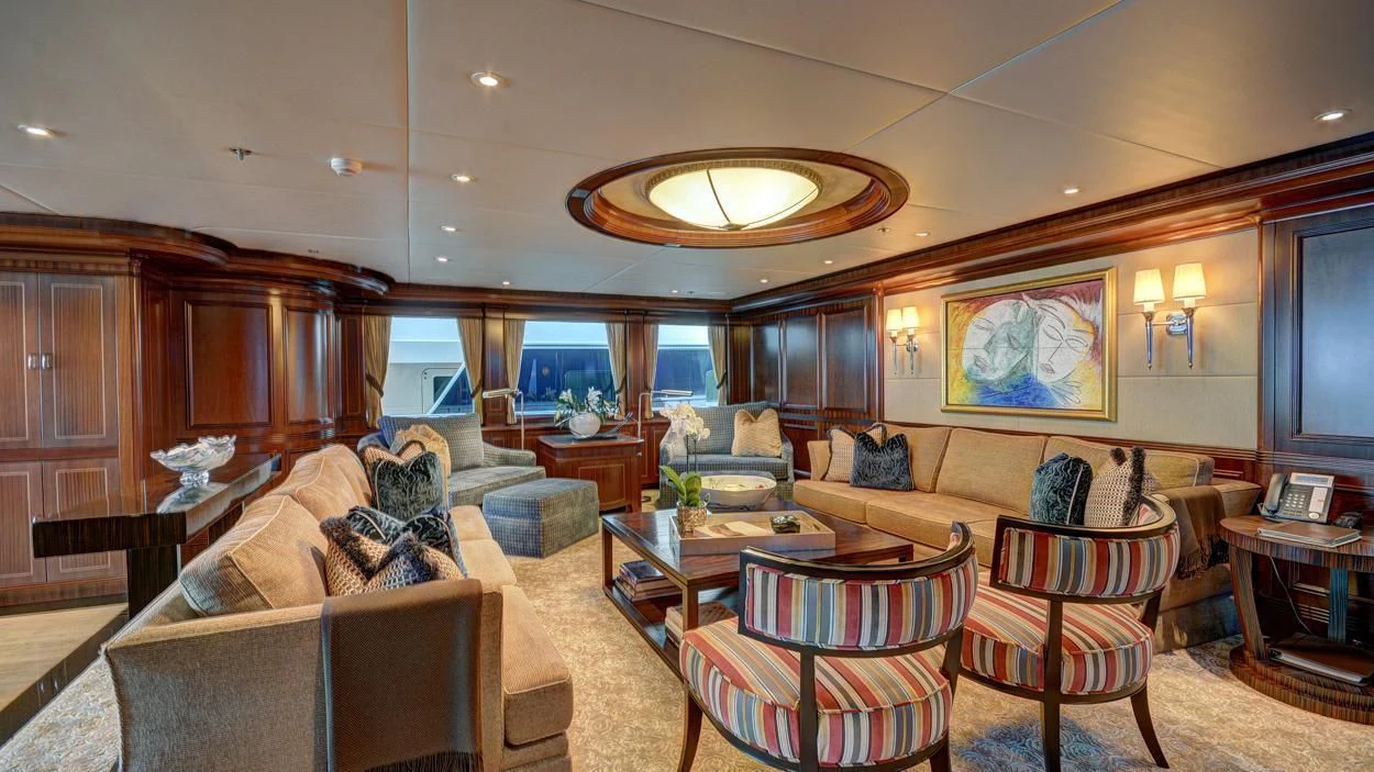 a living room with a leather couch and a large window aboard LADY BETH Yacht for Sale
