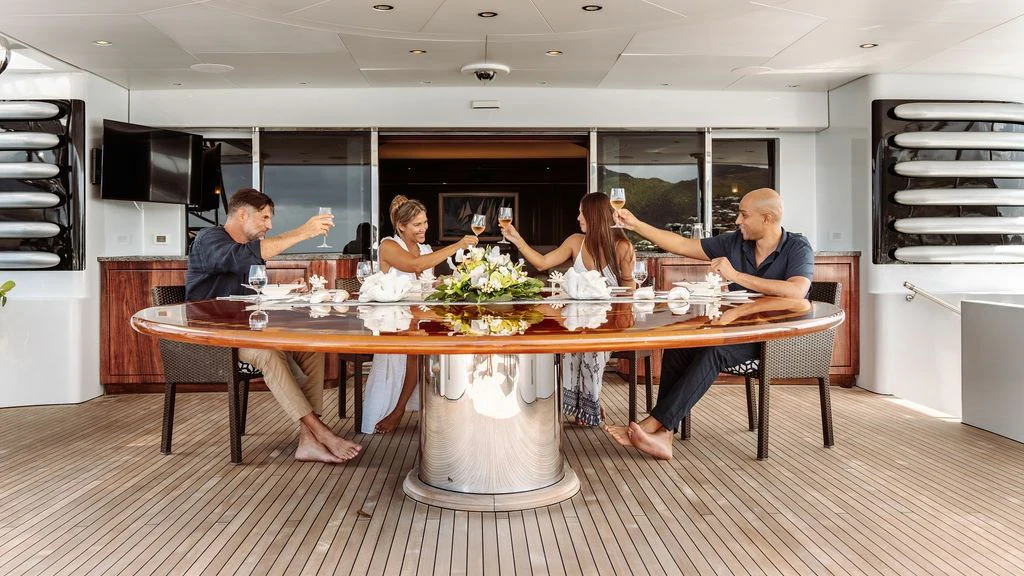 a group of people sitting around a table with food on it aboard LADY BETH Yacht for Sale