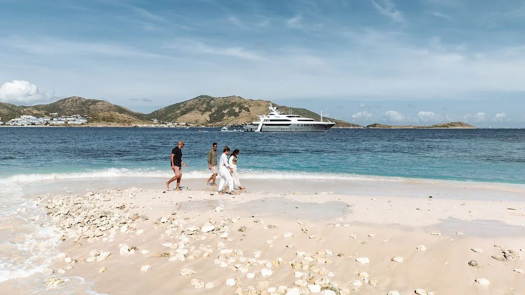 a group of people walking on a beach aboard LADY BETH Yacht for Sale