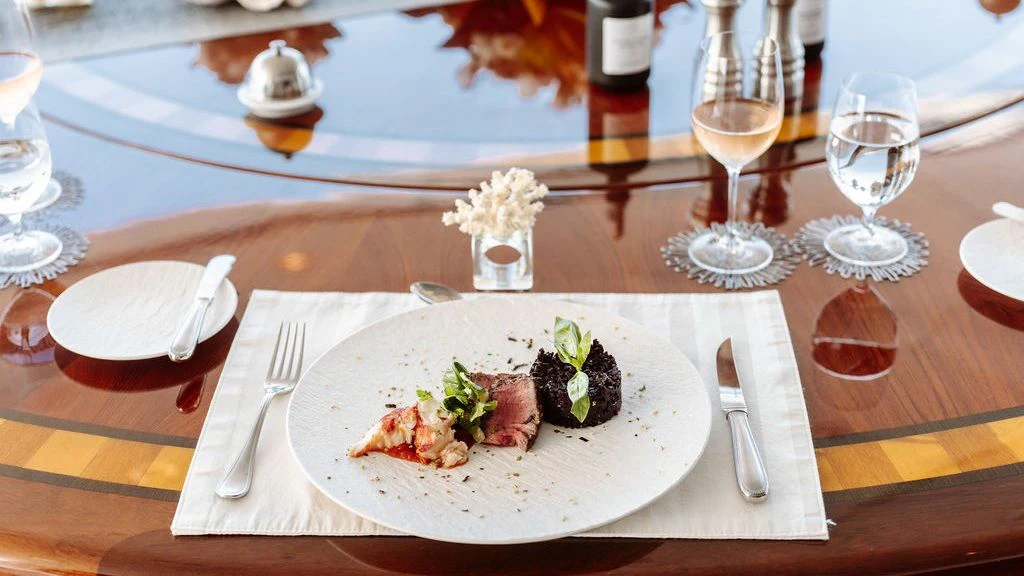 a plate of food and wine aboard LADY BETH Yacht for Sale