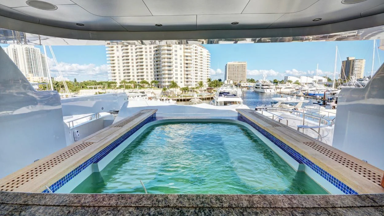 a swimming pool with a city in the background aboard LADY BETH Yacht for Sale