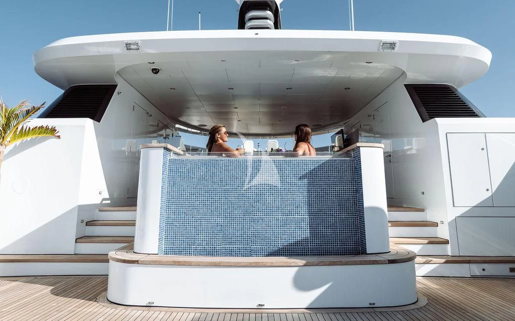a couple of people sitting on a deck looking at a large space ship aboard LADY BETH Yacht for Sale