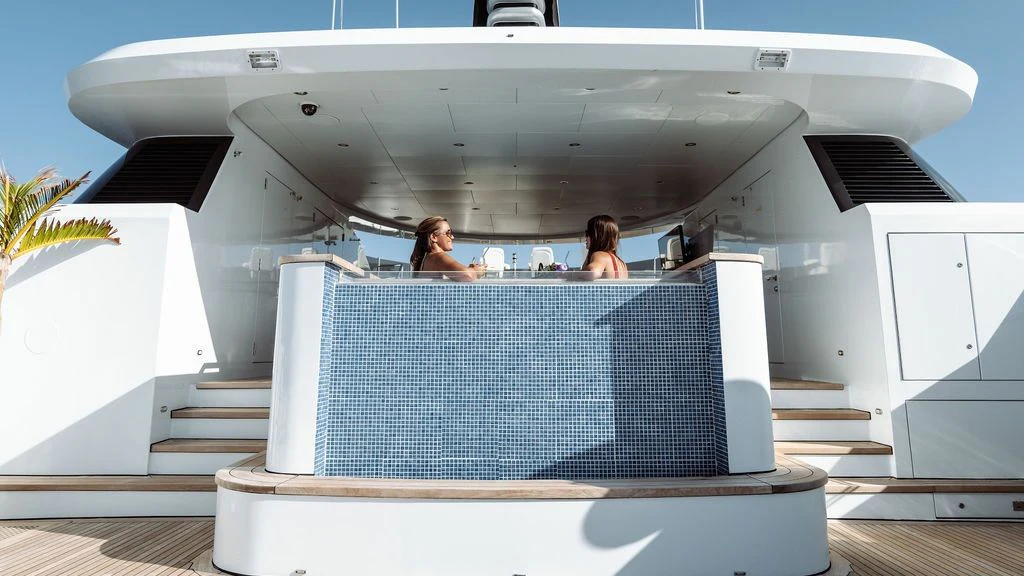 a group of people sitting at a table outside of an airplane aboard LADY BETH Yacht for Sale