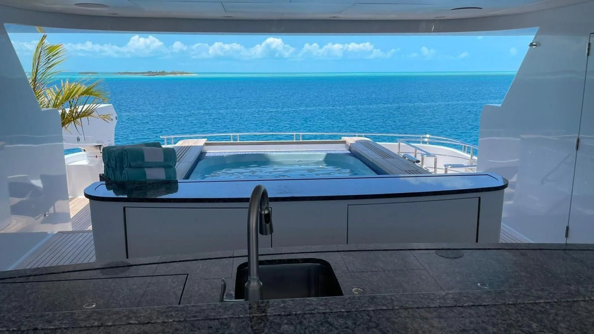 a pool with a chair and a table on a deck by the ocean aboard LADY BETH Yacht for Sale