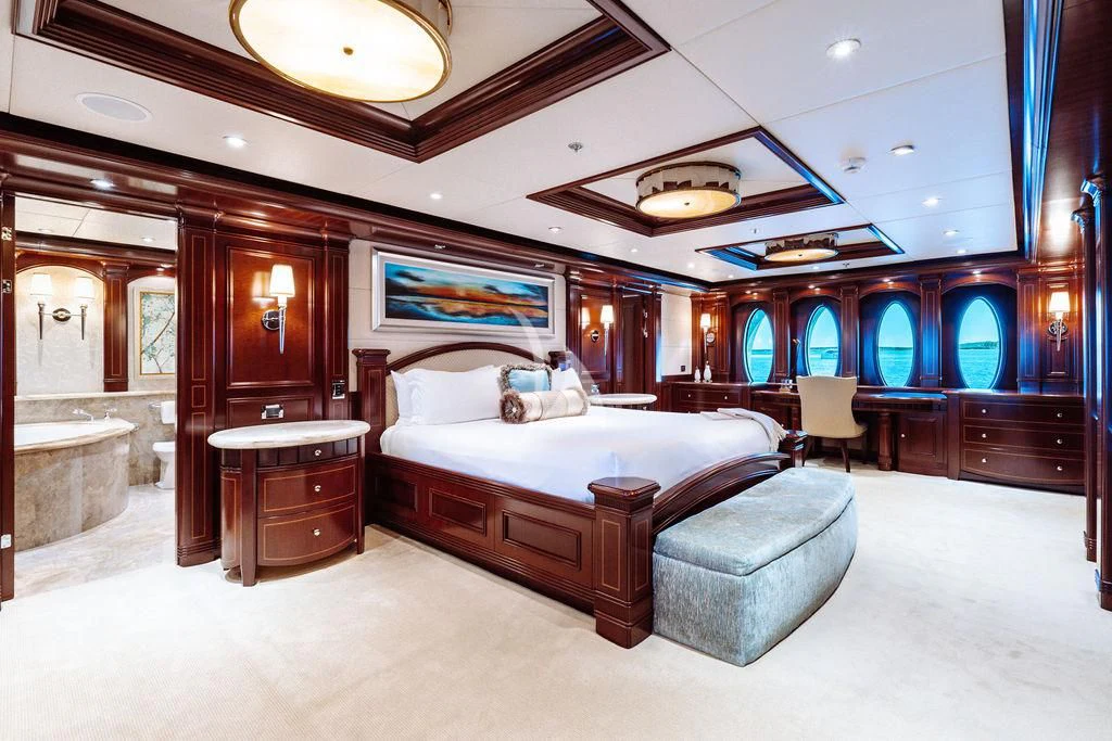 a large bedroom with a bed and a desk aboard LADY BETH Yacht for Sale