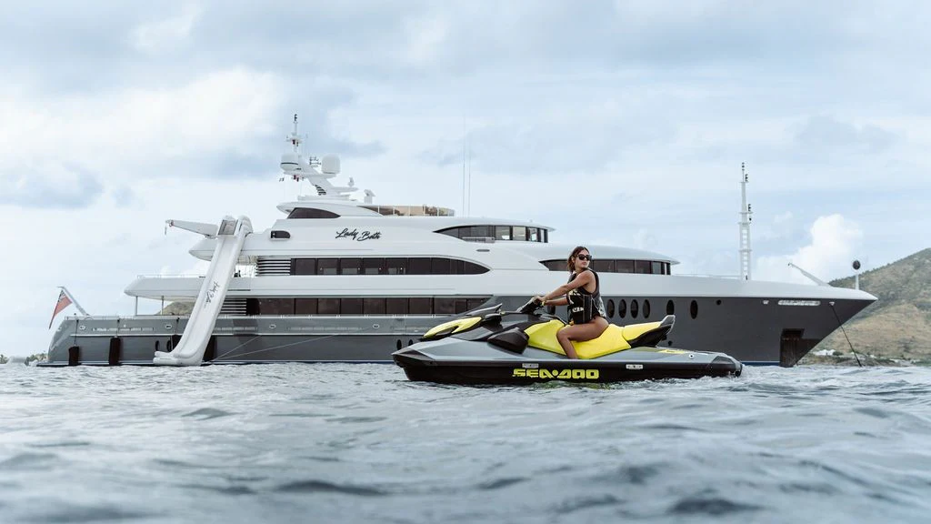 a person on a jet ski in the water next to a large boat aboard LADY BETH Yacht for Sale