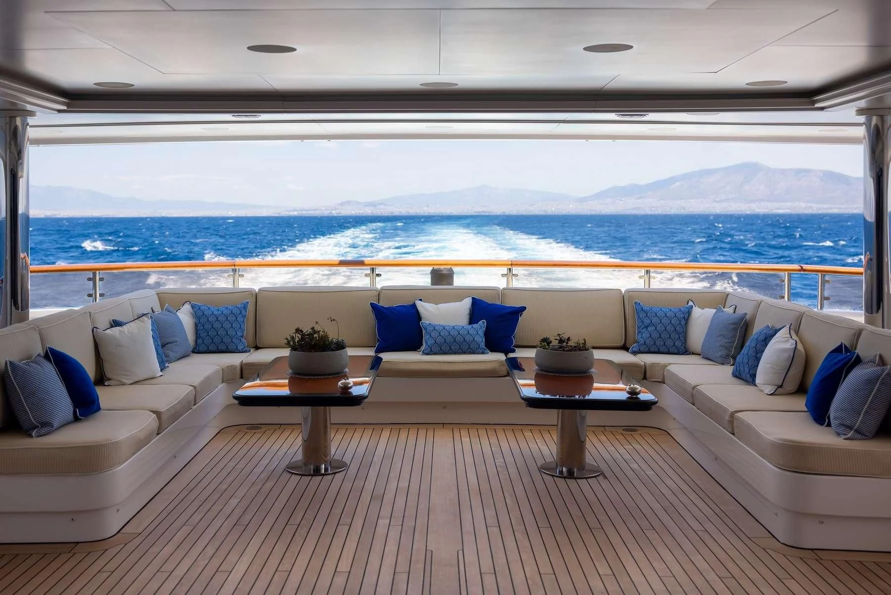 a living room with a large body of water in the background aboard DILARA Yacht for Sale