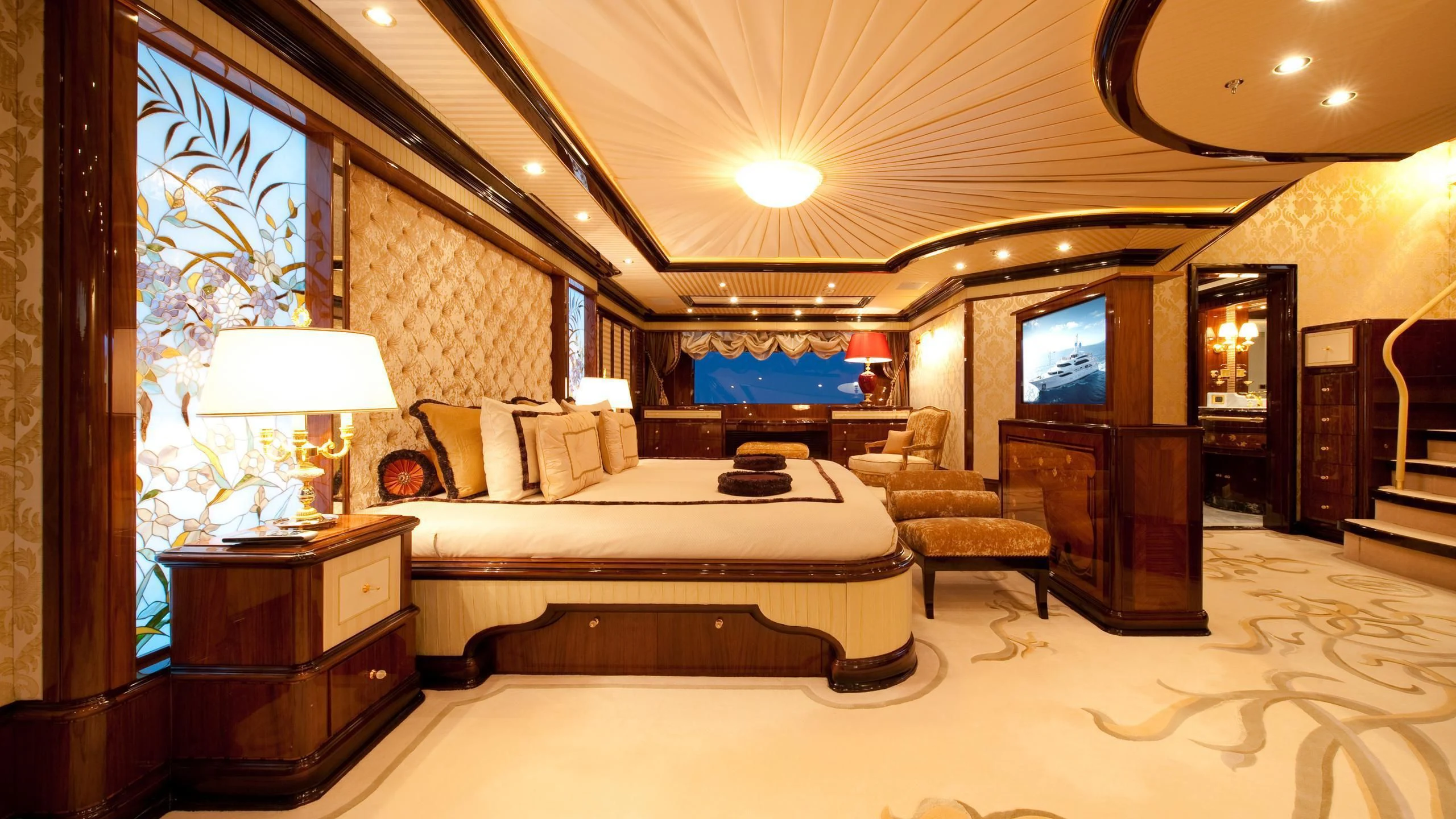 a bedroom with a bed and a chair aboard DILARA Yacht for Sale
