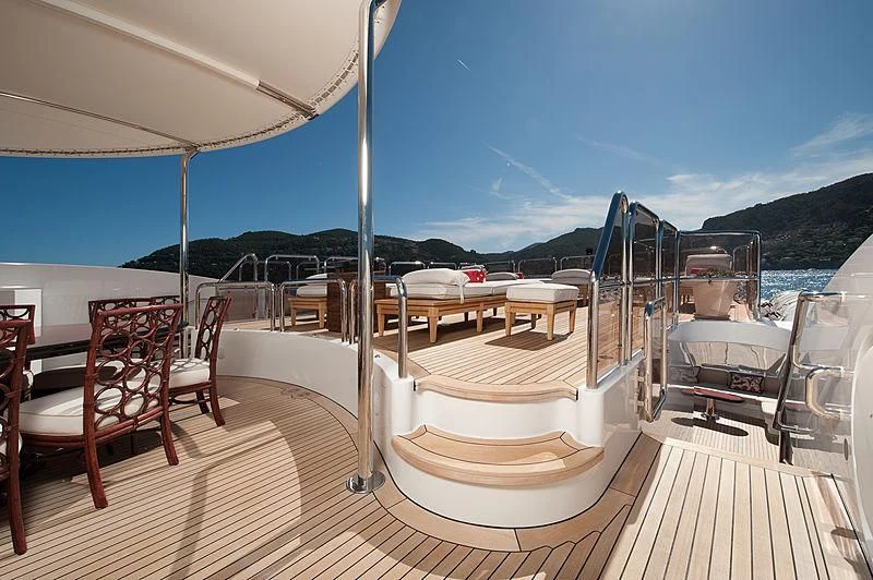 a deck with a view of the water and mountains aboard DILARA Yacht for Sale