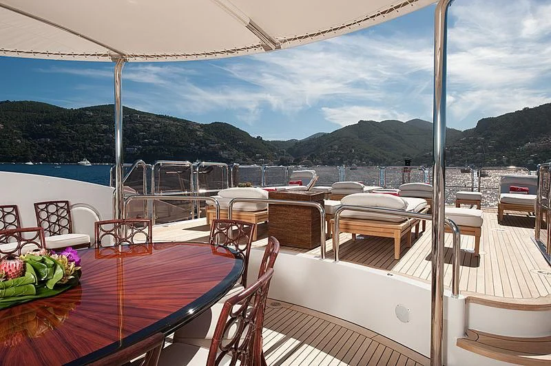 a table on a deck overlooking a body of water aboard DILARA Yacht for Sale