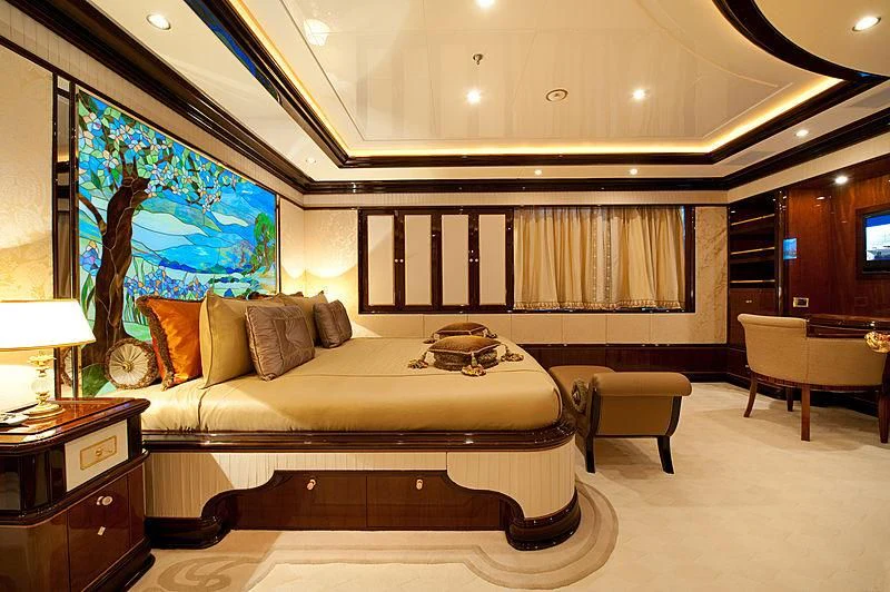a large room with a bed and a painting on the wall aboard DILARA Yacht for Sale