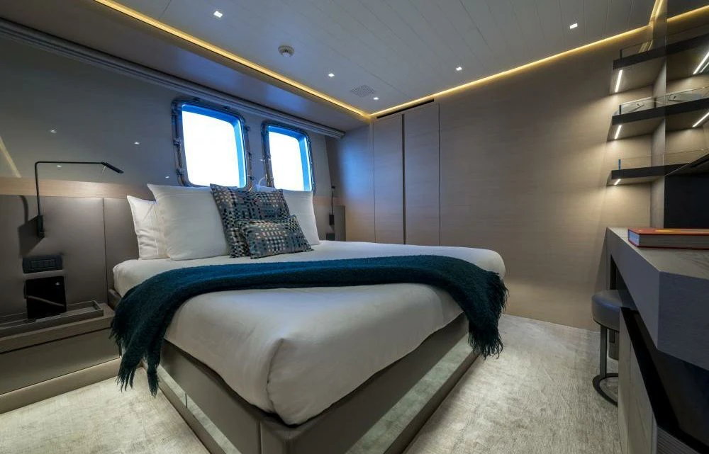 a bedroom with a bed and a desk aboard DILARA Yacht for Sale