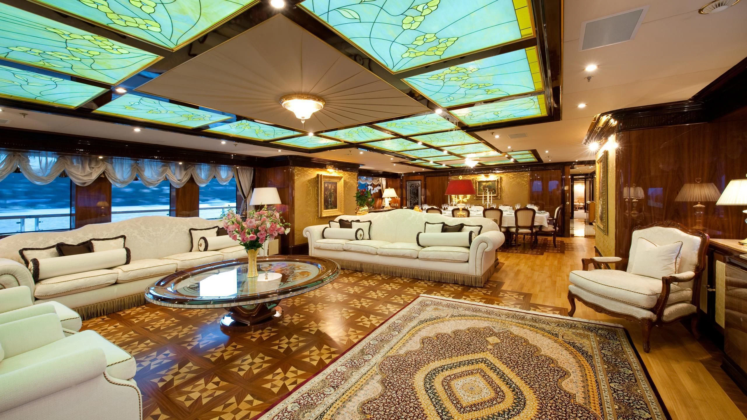 a large living room with a large chandelier aboard DILARA Yacht for Sale