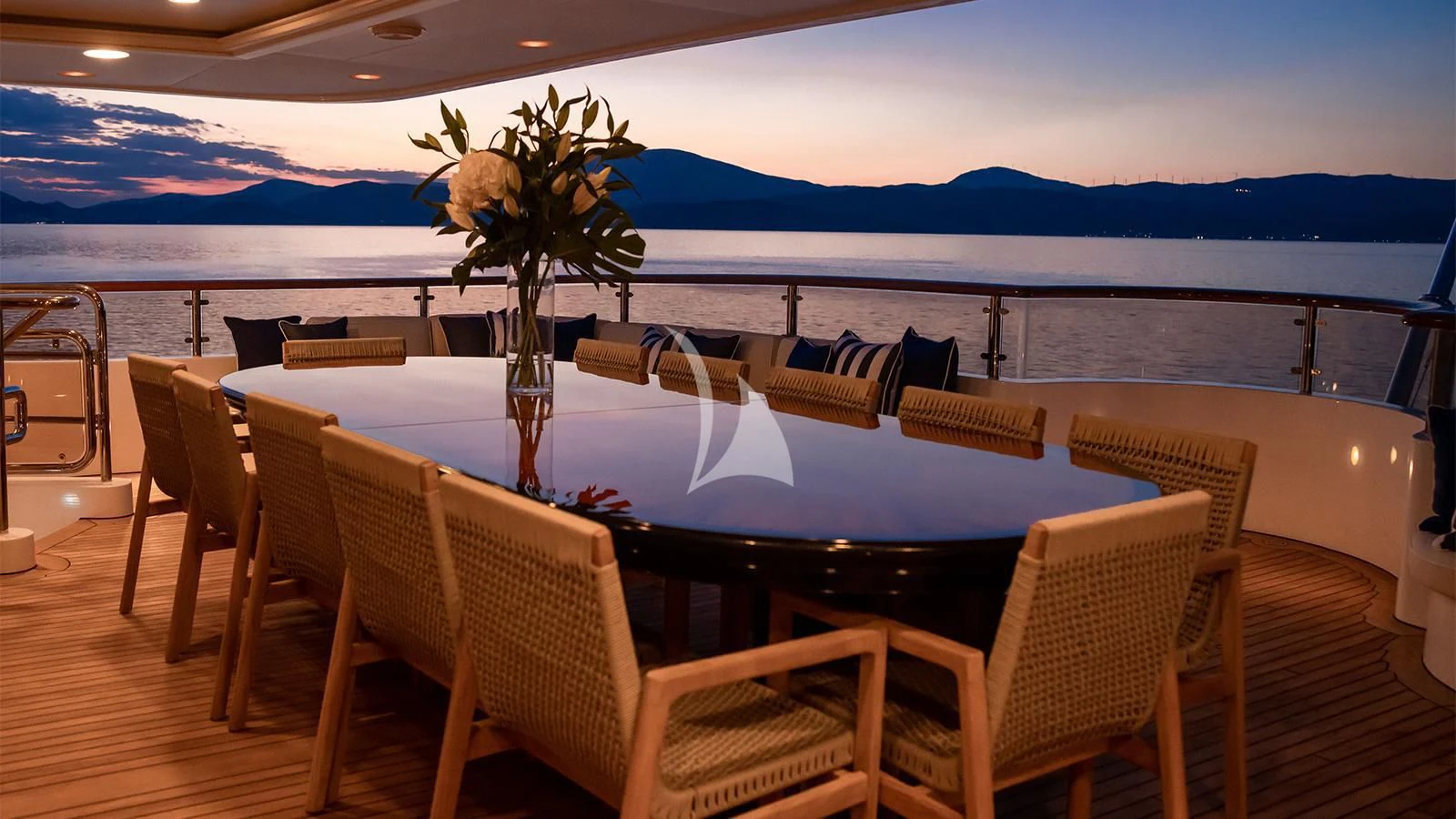 a table with chairs and a view of the ocean aboard DILARA Yacht for Sale