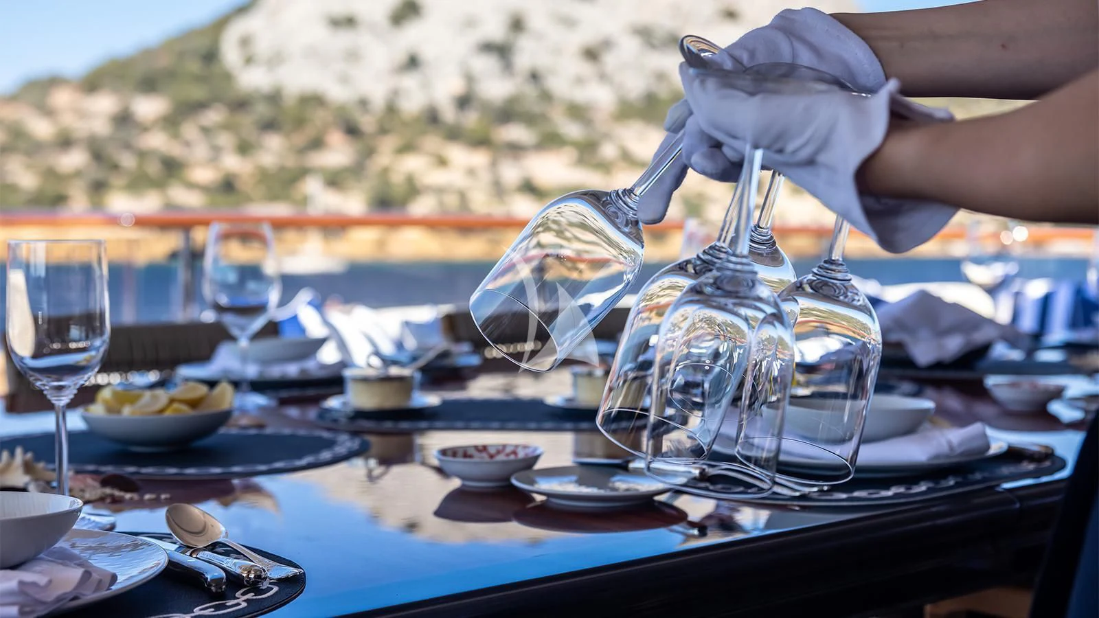 a person pouring liquid into a glass aboard DILARA Yacht for Sale