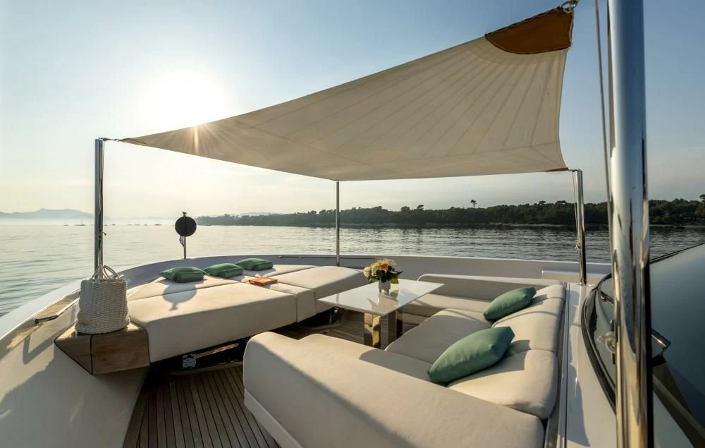 a room with a bed and a table with a lamp on it aboard DILARA Yacht for Sale