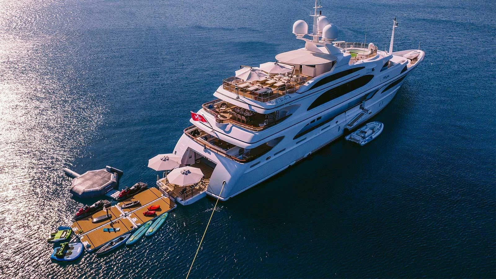 a boat with a dock and a couple of boats on the water aboard DILARA Yacht for Sale