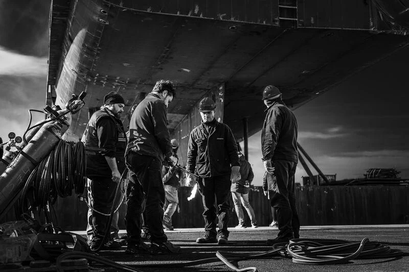 a group of men standing next to a boat aboard AMOR À VIDA Yacht for Sale