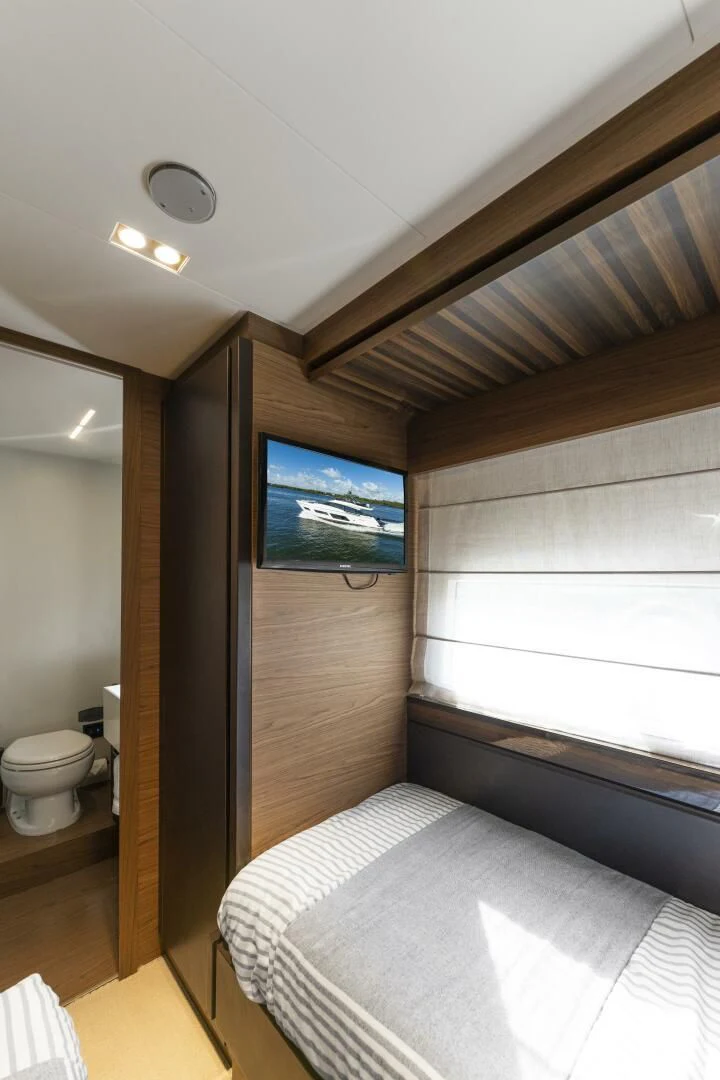 a bedroom with a tv on the wall aboard LEGEND Yacht for Sale