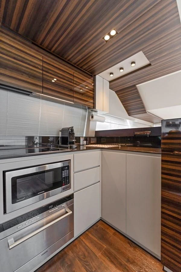 a kitchen with white cabinets aboard LEGEND Yacht for Sale