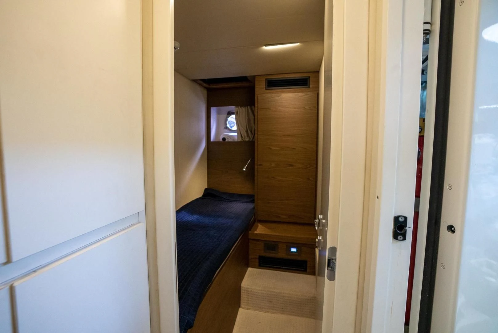 a hallway with a door and a television on the wall aboard LEGEND Yacht for Sale