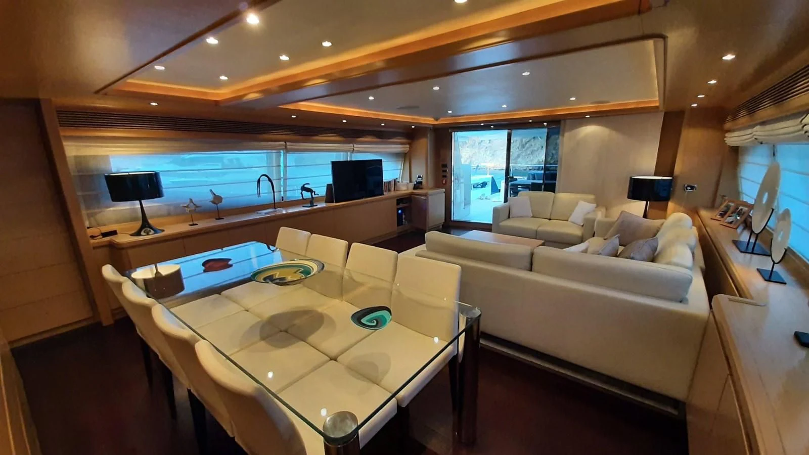 a room with a couch and a table with a laptop on it aboard OKAMI Yacht for Sale