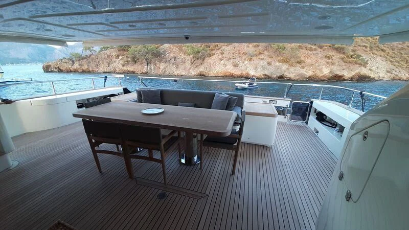a table and chairs on a deck aboard OKAMI Yacht for Sale