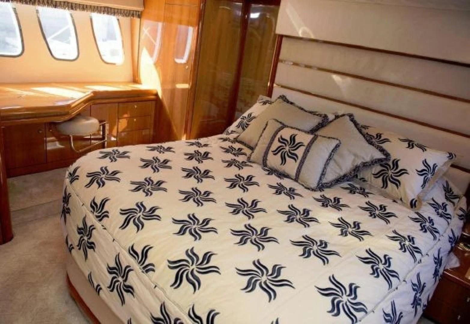 a bed with a blue comforter and white sheets aboard SONSEEKER Yacht for Sale