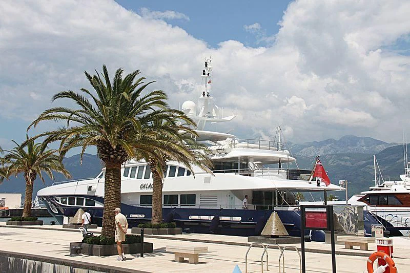 a large white boat with a blue stripe and palm trees aboard RED SAPPHIRE Yacht for Sale