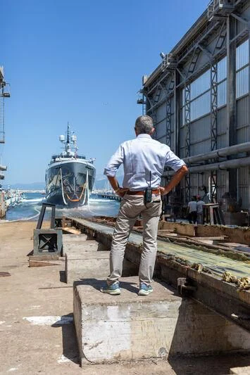 a man standing on a platform looking at a ship aboard KATHRYN Yacht for Sale