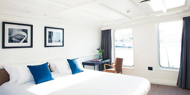 a bed with blue pillows aboard MENORCA Yacht for Sale