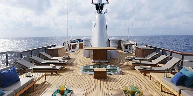 a deck with a pool and a large ship in the background aboard MENORCA Yacht for Sale