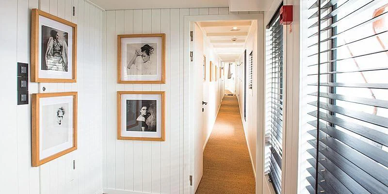 a hallway with framed pictures aboard MENORCA Yacht for Sale