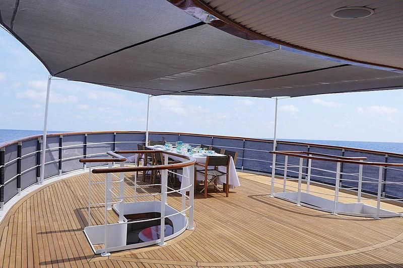 a deck with a table and chairs on it aboard MENORCA Yacht for Sale