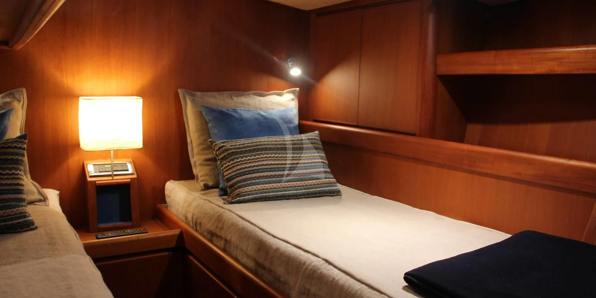 a bed with pillows and a lamp aboard WALLY ONE Yacht for Sale