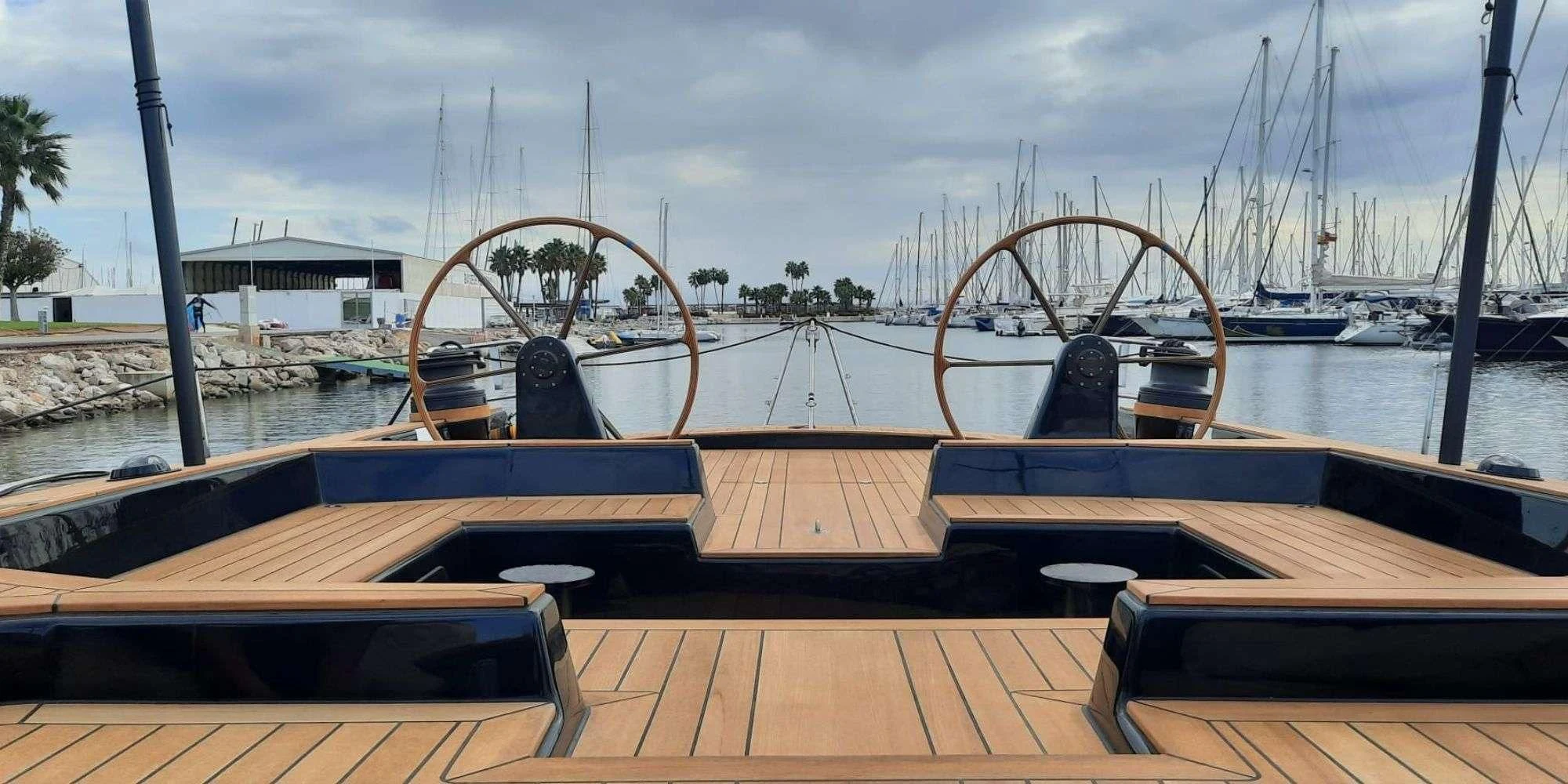 a wooden deck with a roller coaster and a roller coaster in the background aboard WALLY ONE Yacht for Sale