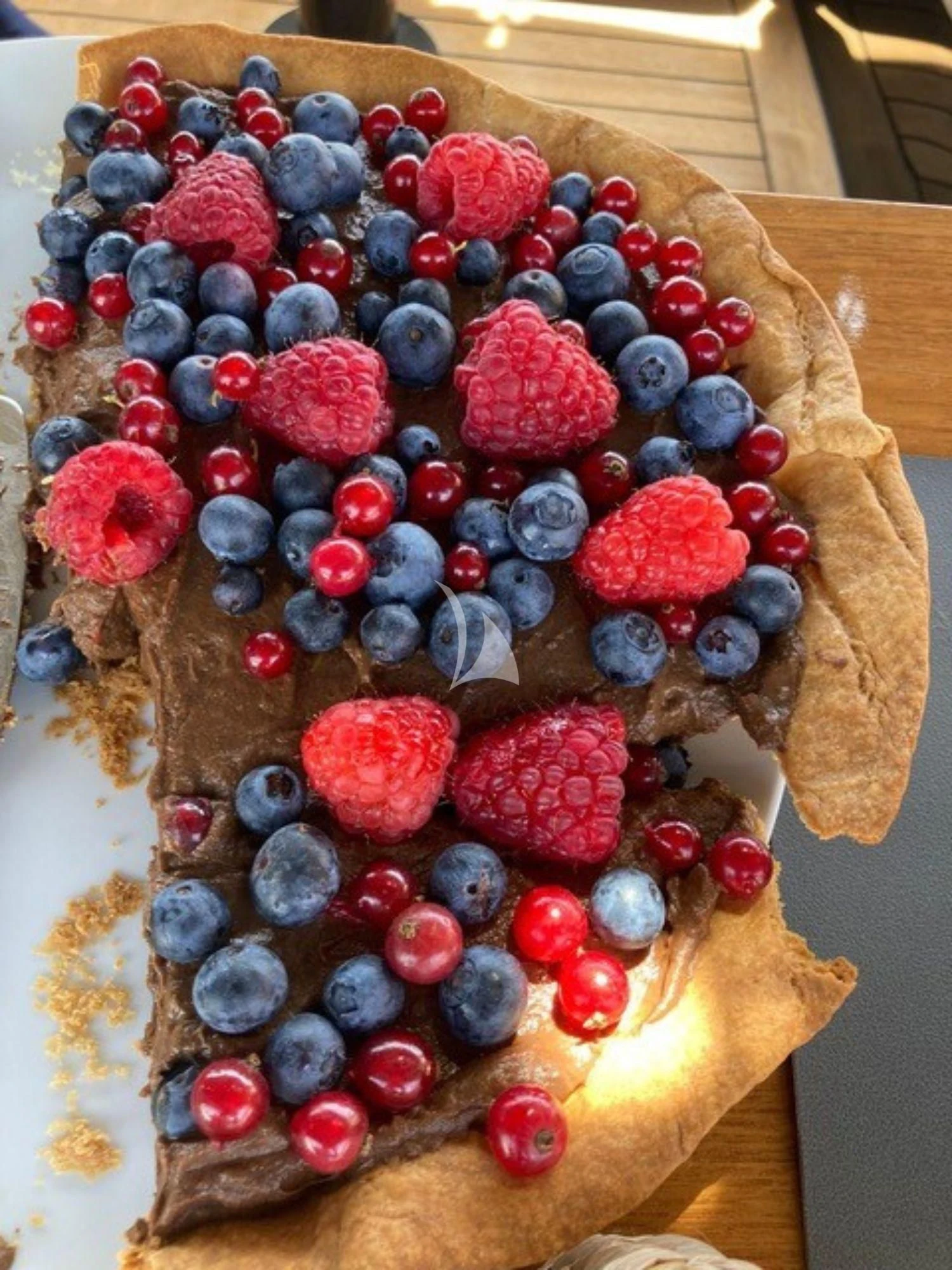 a cake with berries on top aboard WALLY ONE Yacht for Sale