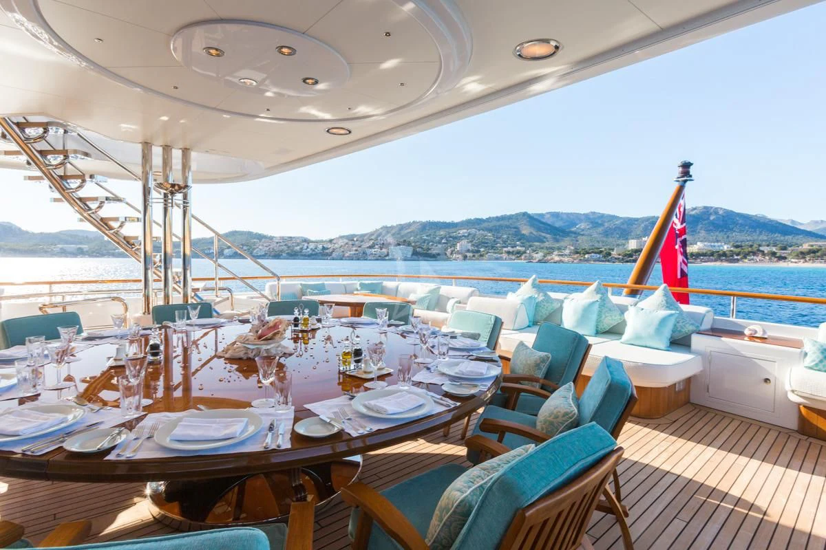 a room with a table and chairs and a view of the water aboard NECTAR Yacht for Sale