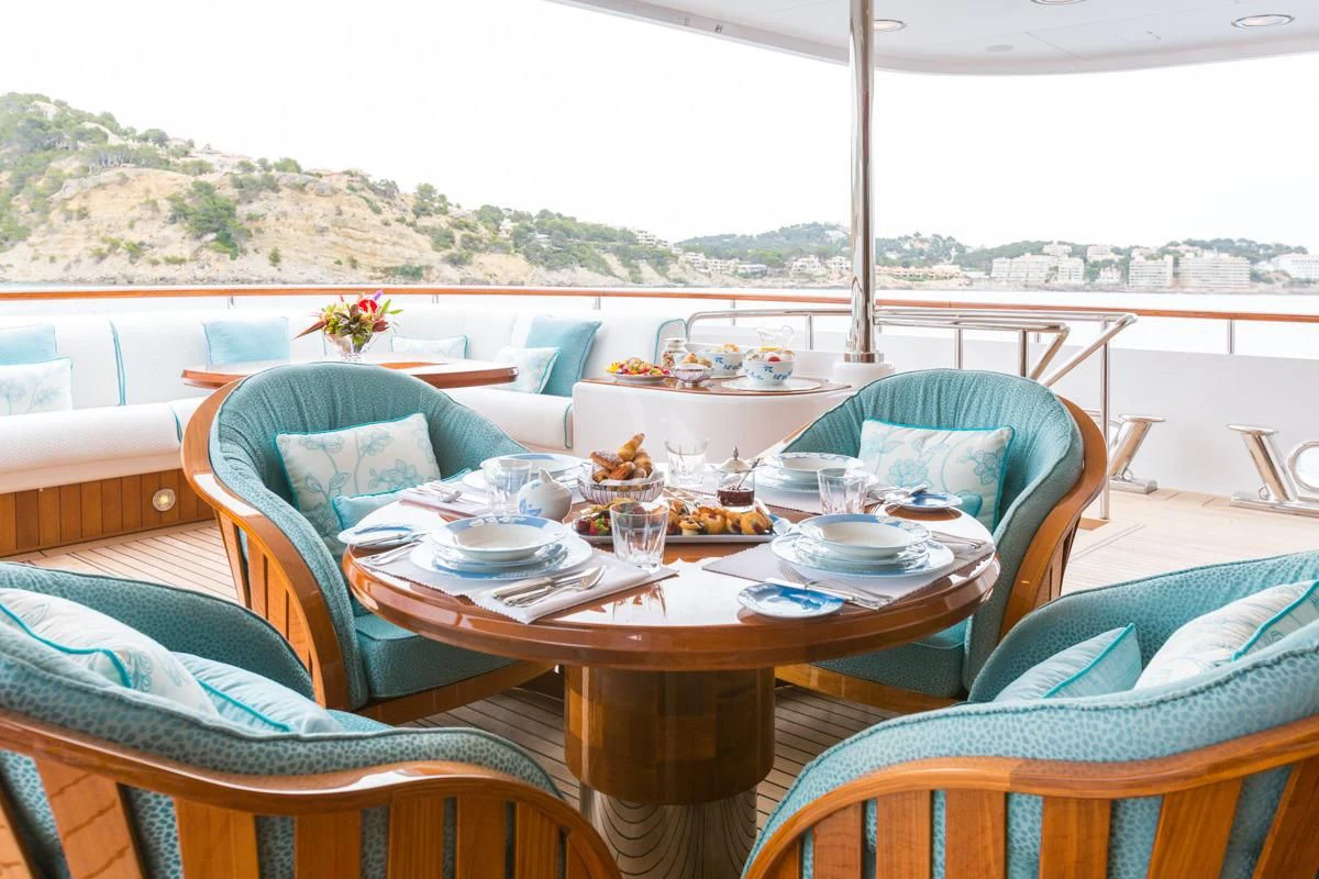 a table set with plates and chairs aboard NECTAR Yacht for Sale