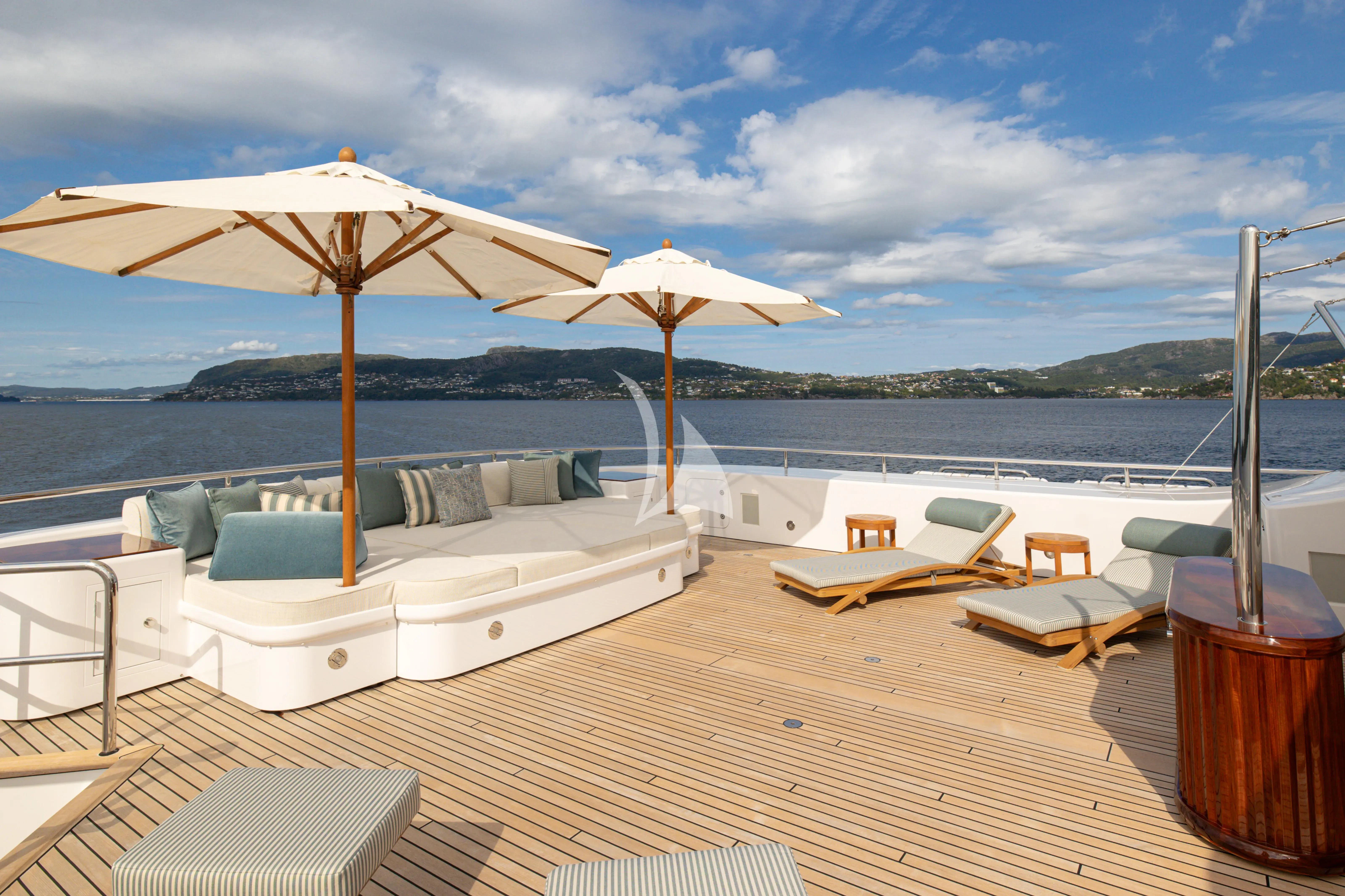 a lounge area with chairs and umbrellas on it aboard NECTAR Yacht for Sale