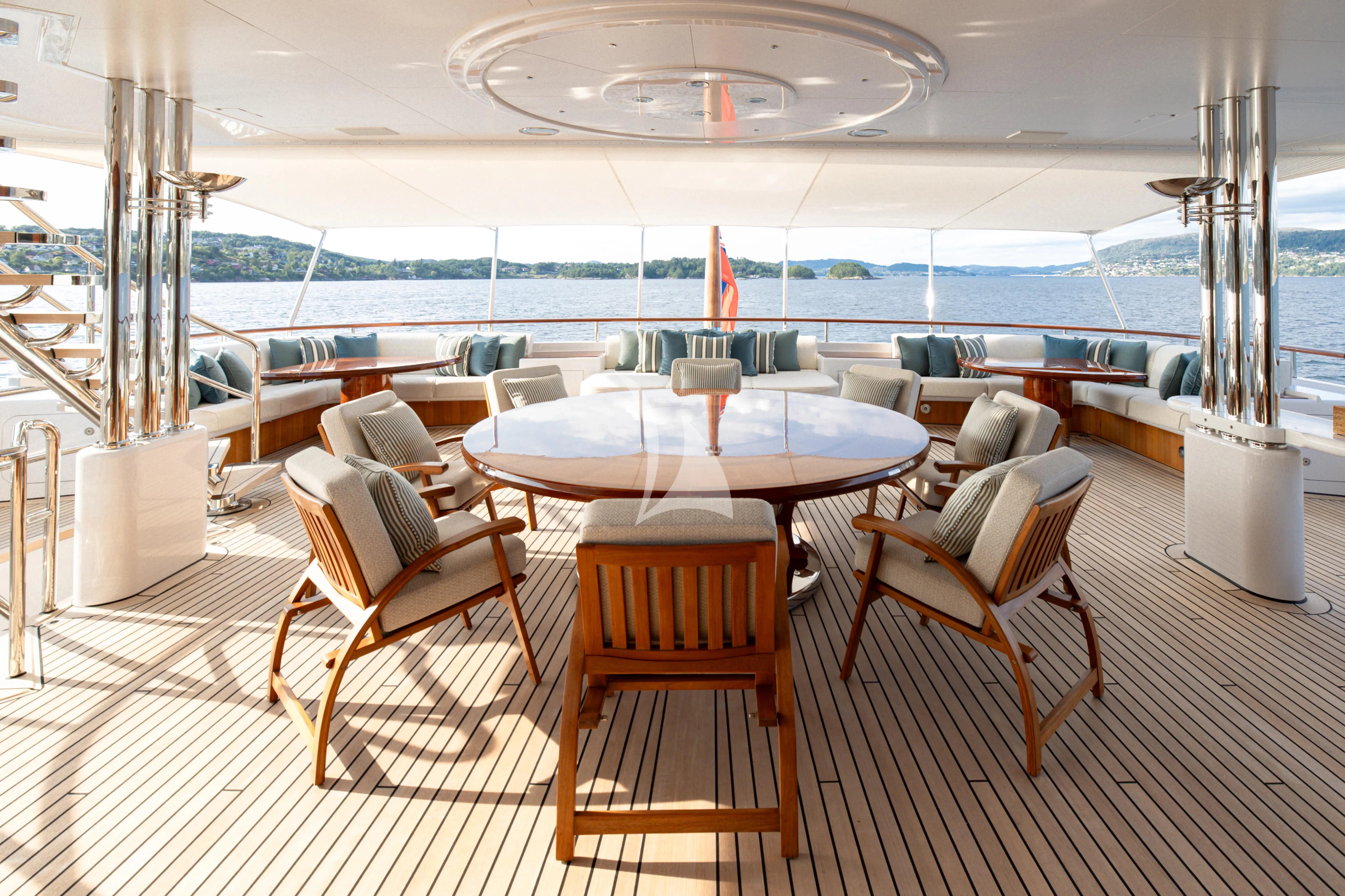 a room with a table chairs and a view of the water aboard NECTAR Yacht for Sale