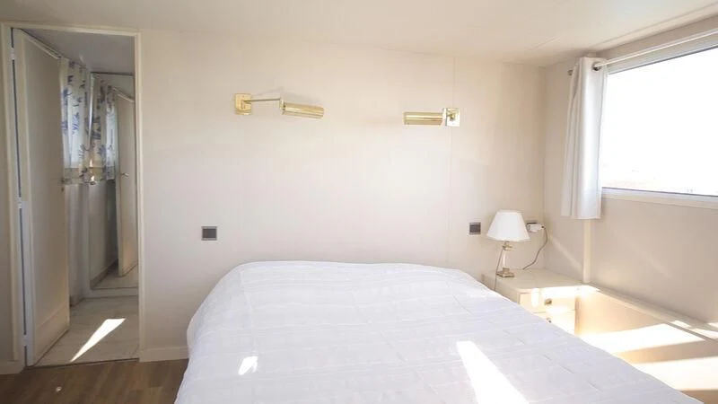 a bedroom with a bed and a lamp aboard MARAM Yacht for Sale