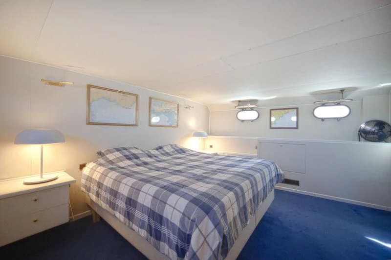 a bedroom with a bed and a lamp aboard MARAM Yacht for Sale