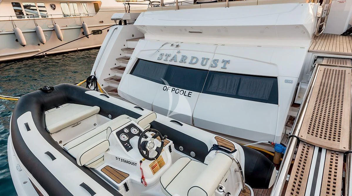 a white boat with a black and silver boat on the water aboard STARDUST OF MARY Yacht for Sale