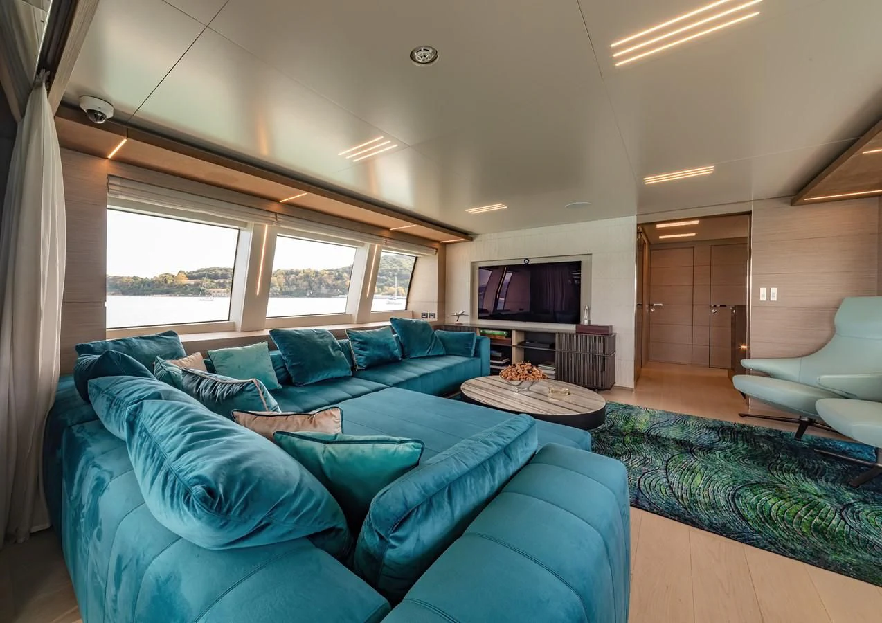 a living room with a blue couch aboard FRANGELO Yacht for Sale