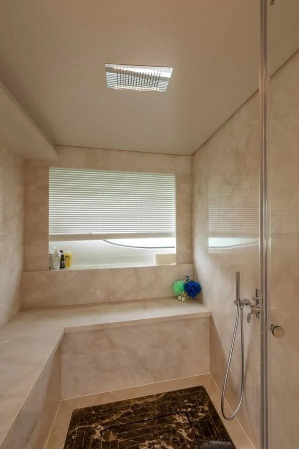 a bathroom with a shower and a window aboard FRANGELO Yacht for Sale