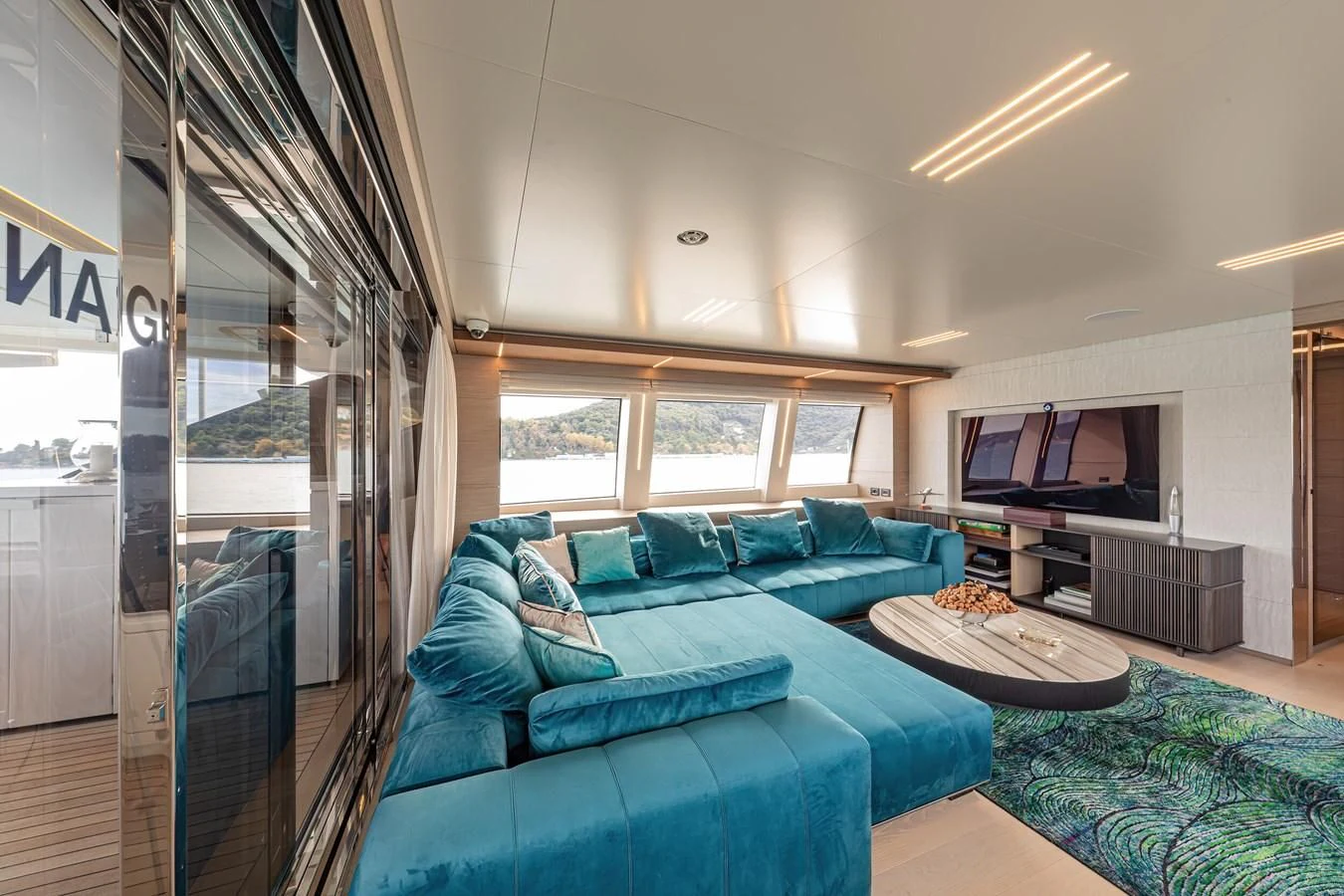a living room with a blue couch aboard FRANGELO Yacht for Sale