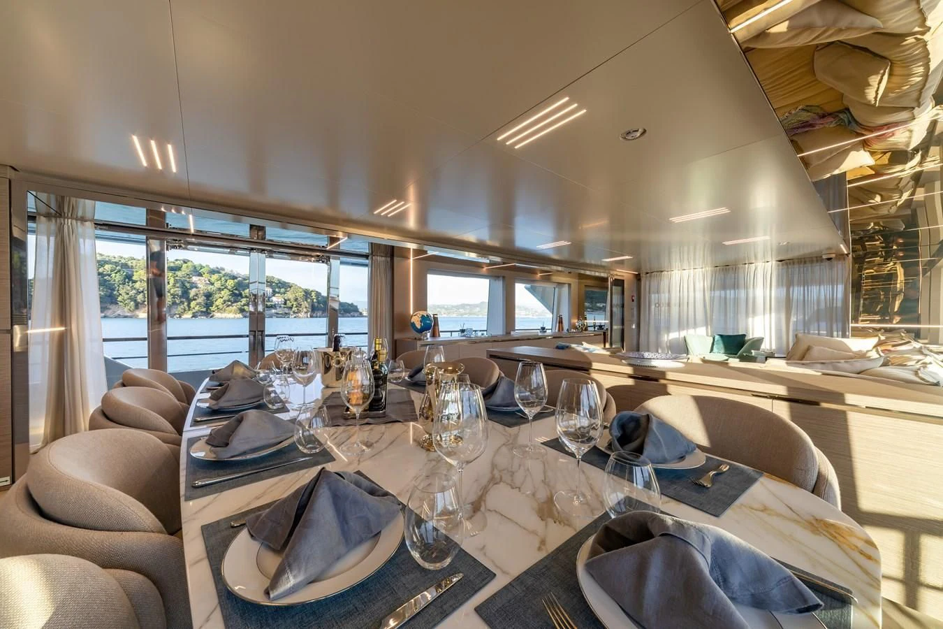 a dining table with chairs and a large window aboard FRANGELO Yacht for Sale