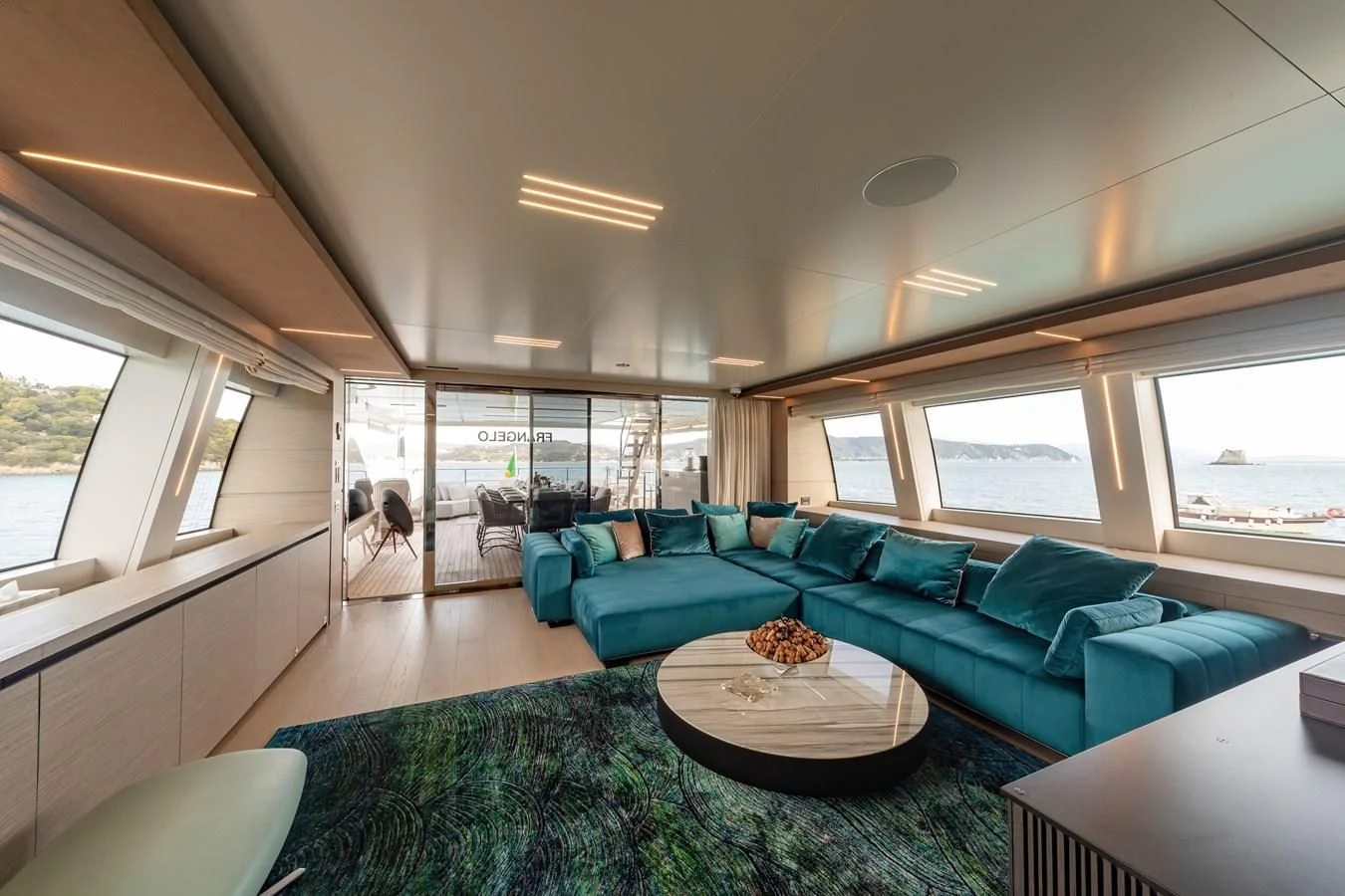 a living room with a blue couch aboard FRANGELO Yacht for Sale